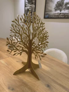 Arbre de vie décoratif en métal posé sur une table en bois d'agence.