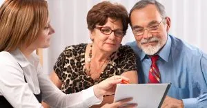 Couple senior en entretien de prévoyance obsèques avec un conseiller.